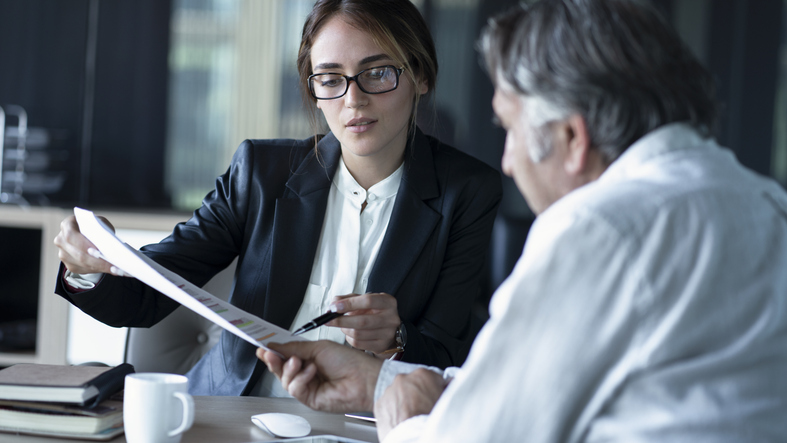 A man consulting a financial advisor about his Roth IRA.