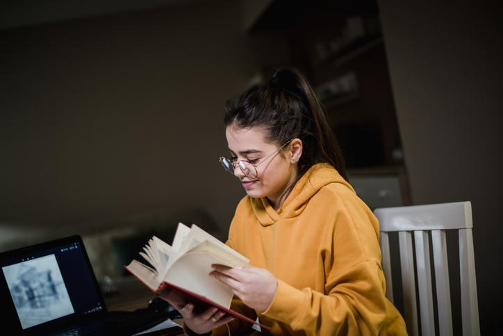 A Millennial reading a book about retirement planning strategies.