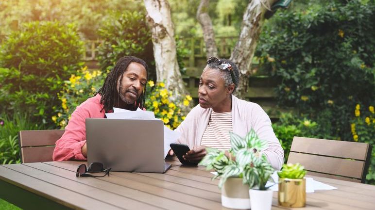 A middle-age couple looks over their retirement savings as they consider making catch-up contributions. 