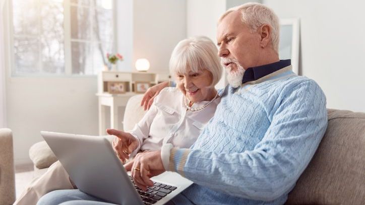 A couple examines their Social Security benefits on a laptop. 