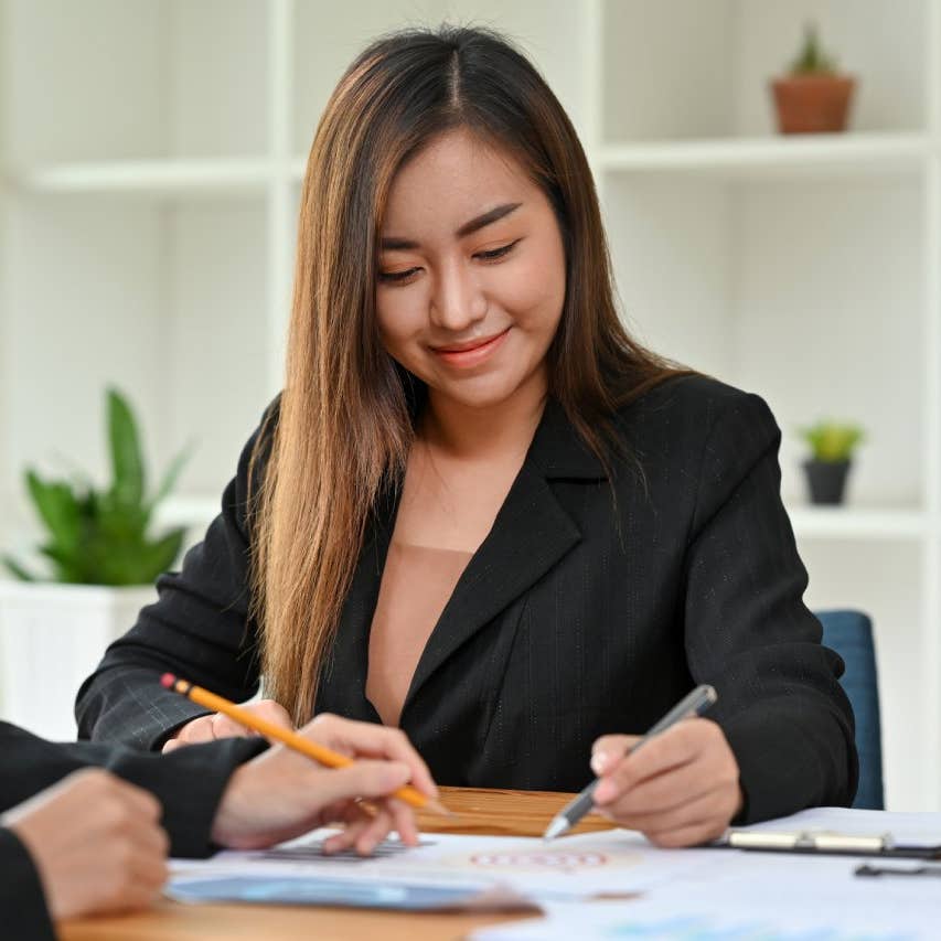 Asian woman signing papers